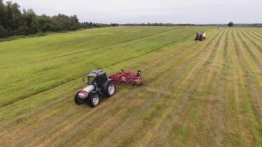 Viborg, Rusya - 11 Haziran 2018: Dron kamera görünümünü çalışma kırmızı yuvarlak şekilli tırmık ile hareket büyük gri traktör