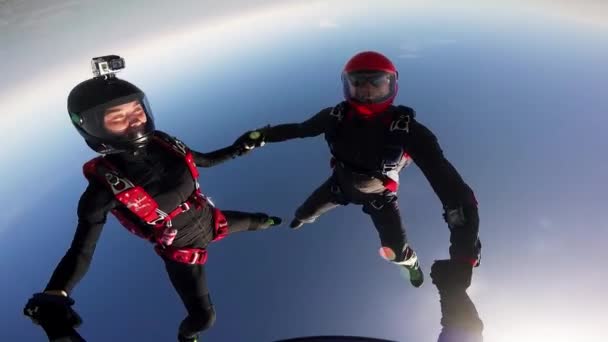 MOSCÚ, RUSIA - 10 DE JUNIO DE 2015: Paracaidistas tomados de la mano en el cielo nublado. Día soleado. Deporte extremo. Profesionales — Vídeo de stock