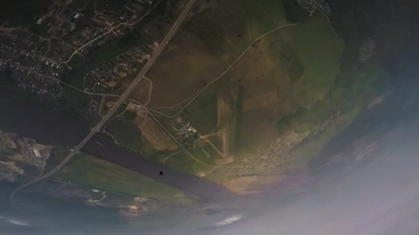 Moskou, Rusland - 10 juni 2015: Skydiver open parachute, vliegen over de groene velden. Bewolkte hemel. Extreme sporten. — Stockvideo