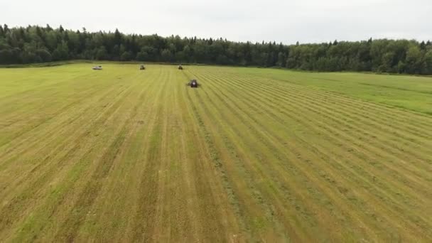 Sky view of big grey tractor moving with working attached red round shaped rakes — Stock Video