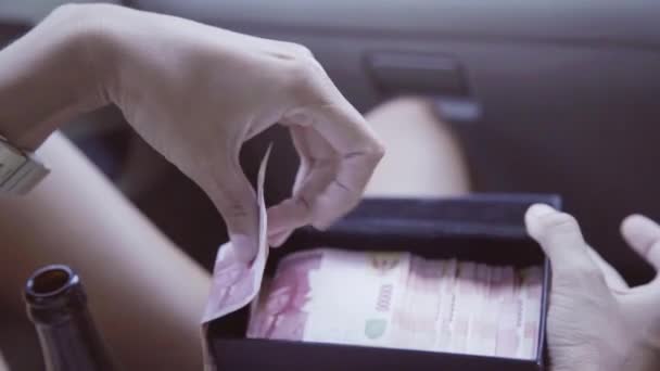 Στο αυτοκίνητο ώριμη γυναίκα παίρνει έξω τραπεζογραμματίων από το μαύρο κουτί με ξένο νόμισμα — Αρχείο Βίντεο