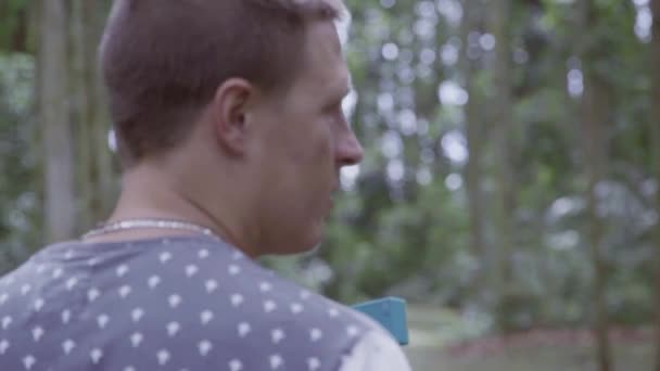 Dos amigos caucásicos con camiseta están hablando y caminando en el parque forestal — Vídeos de Stock