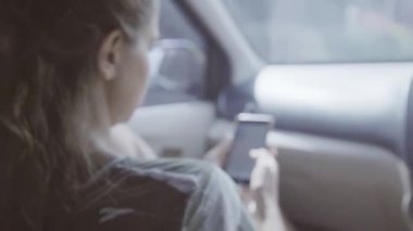 Fotoğraf makinesi akıllı telefon olan kadın araba, sonra sevimli uzun saçlı adam gösterir.