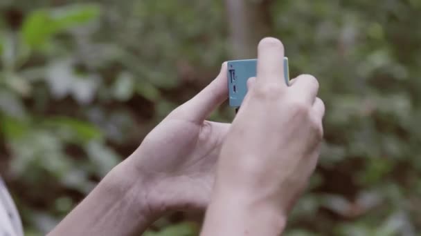 Retrato de jovem caucasiano fumando e segurando câmera de ação com monopod . — Vídeo de Stock