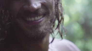 Islak kıvırcık saçlı Sevimli genç adam sırt, gülümsüyor alır ve kameraya benziyor