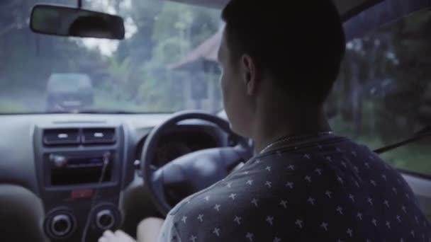 Jovem caucasiano de cabelos curtos homem está dirigindo carro de condução à direita na estrada rural . — Vídeo de Stock