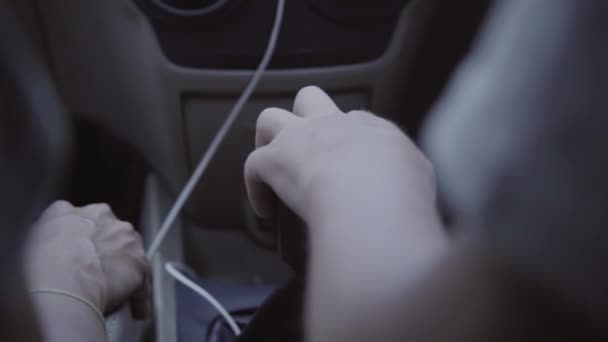 Binnenkant van bewegende auto cabine met zwarte handgeschakelde transmissie met twee passagiers — Stockvideo