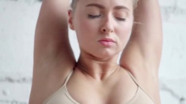 Sportif beyaz kadının gün ışığı Studio'da egzersiz germe el işi.