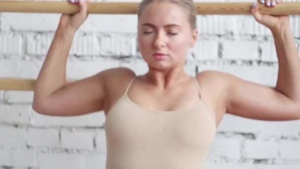 Esportivo caucasiano bonito mulher em leotard está fazendo exercícios de balé no barre . — Vídeo de Stock