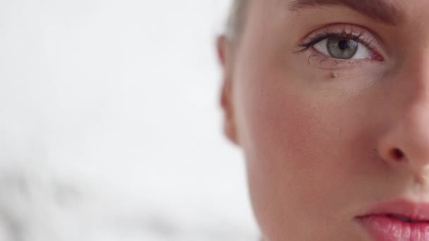 Beautiful face of young caucasian woman with big grey eyes on white background. — Stock Video