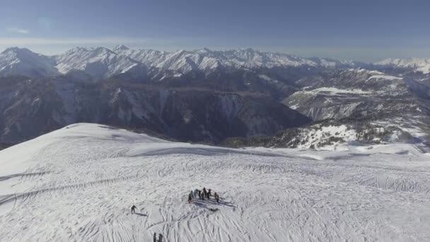 BAKURIANI, GEORGIA - 2 DE NOVIEMBRE DE 2017: Grupo de esquiadores mira a la cámara y a las olas con las manos en la cima de la colina cubierta de nieve — Vídeos de Stock