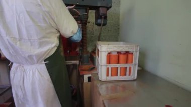 Makine dönen turuncu plastik tüpler laboratuvar işçinin elbise-üniformalı koyar