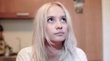 Tavana merak yüz bakışları ile sevimli gülümseyen sarışın genç kahverengi gözlü.