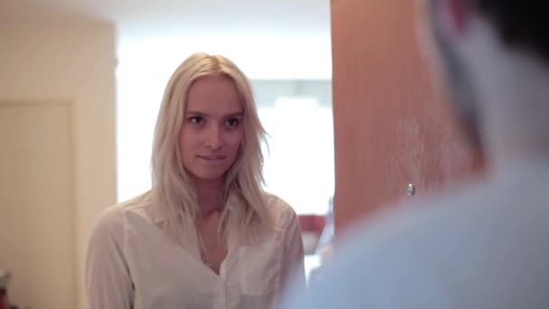 Hübsches blondes Mädchen mit Lächeln steht vor offener Tür, sieht Mann an, der sie umarmt — Stockvideo