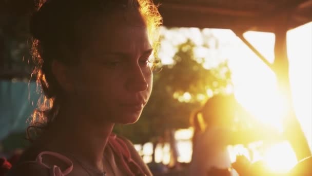 Linda mujer joven se sienta en chaise-longue, come sandía y pizza al atardecer . — Vídeos de Stock