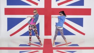 İki sevimli komik kız Studio İngiltere'de bayrak duvar kağıtları ile dans provası