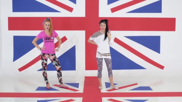 Probe von zwei Tänzerinnen, die vor dem Hintergrund der britischen Flagge stehen — Stockvideo