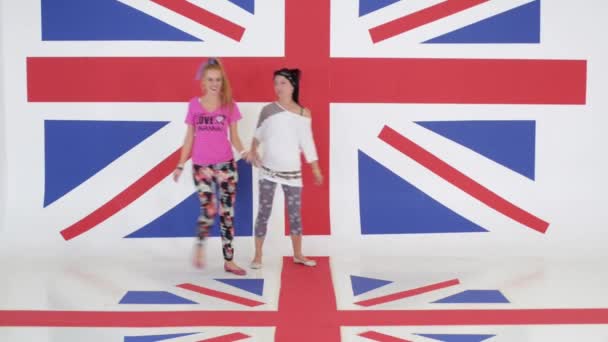 Zkouška ze dvou okouzlující ženy tančí na pozadí textury vlajka Velké Británie.