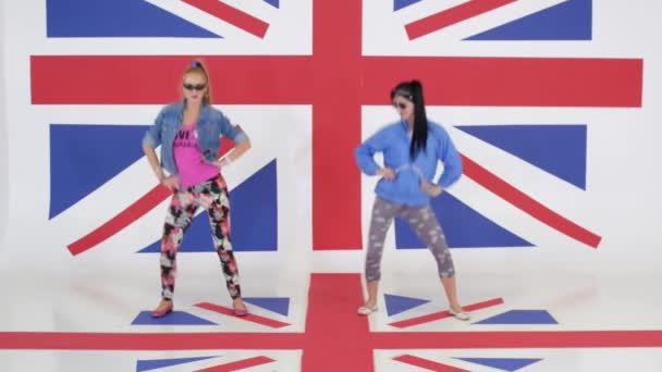 Ensayo de dos chicas con gafas de sol bailando sobre fondo de textura de bandera del Reino Unido . — Vídeos de Stock