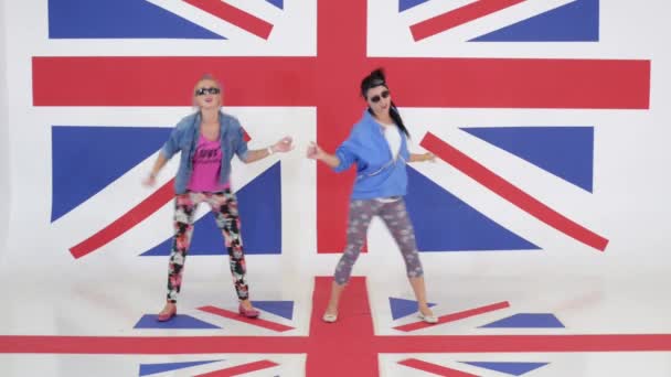 Cámara muestra ensayo de dos intérpretes de danza femenina en el fondo de la bandera del Reino Unido — Vídeos de Stock