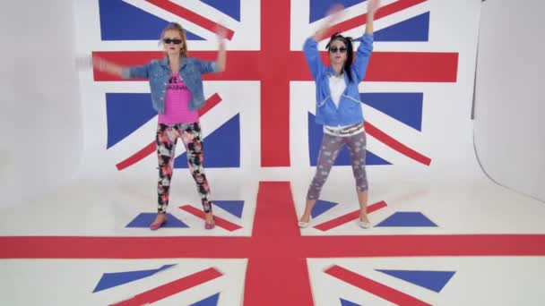 İngiltere bayrak duvar kağıtları ile stüdyoda fotoğraf makinesinde iki kadın dansçı pratik — Stok video