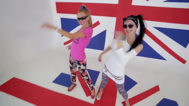 Deux jolies femmes en t-shirts fixent la caméra et dansent synchroniquement . — Video