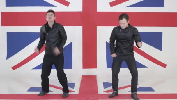 Dos hombres lindos en cuero negro chaquetas de moto bailan y cantan en la cámara . — Vídeos de Stock