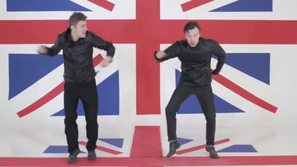 Два симпатичных мужчины в черных кожаных куртках мотоцикла синхронно танцуют и поют — стоковое видео