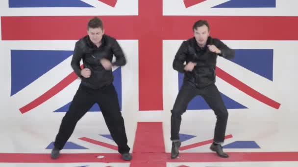 Two good-looking guys in black leather motorcycle jackets synchronically dance. — Stock Video