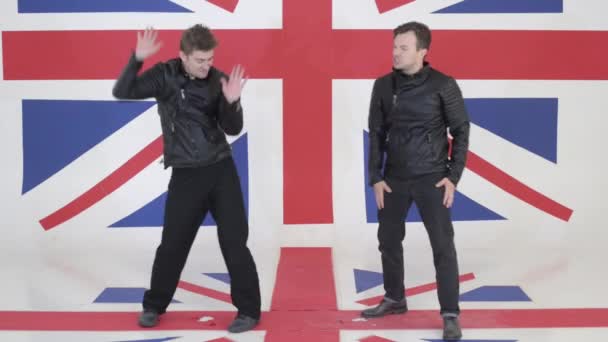 Two good-looking guys in black leather motorcycle jackets dance and sing. — Stock Video