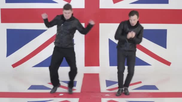 Two good-looking guys in black leather motorcycle jackets energetically dance. — Stock Video