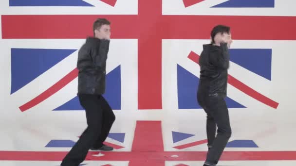 Two good-looking males in black leather motorcycle jackets energetically dance. — Stock Video