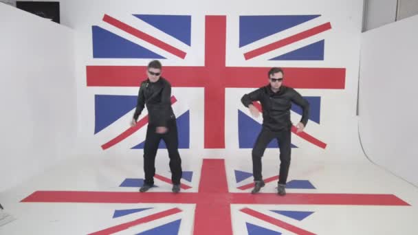 Két aranyos srácok a érett fekete bőr motoros kabát és napszemüveg tánc. — Stock videók