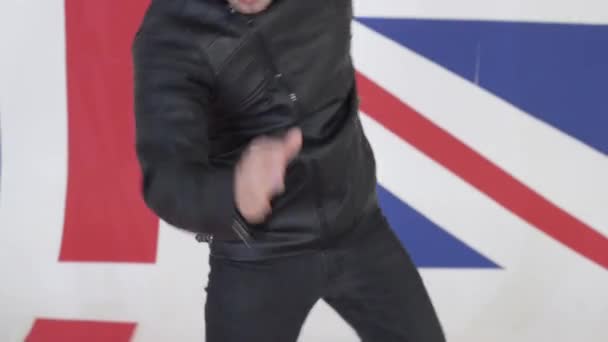 かわいい若い男が身に着けている黒革バイク ジャケット積極的に踊り — ストック動画