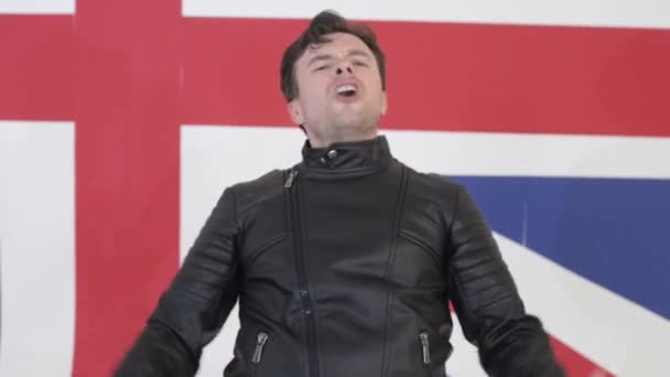 Cute young man dressed in black leather motorcycle jackets sings and dances — Stock Video