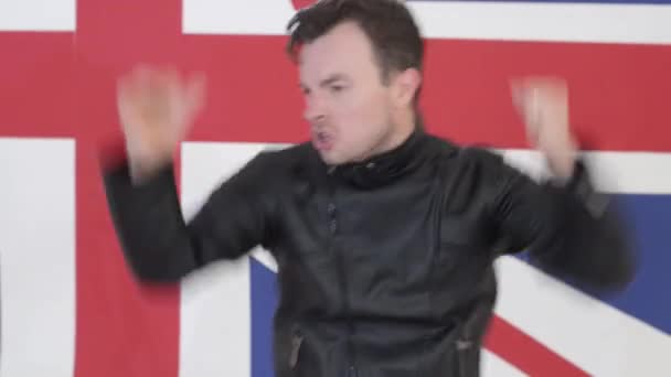 Hombre atractivo vestido con chaqueta de moto de cuero negro canta y baila — Vídeo de stock