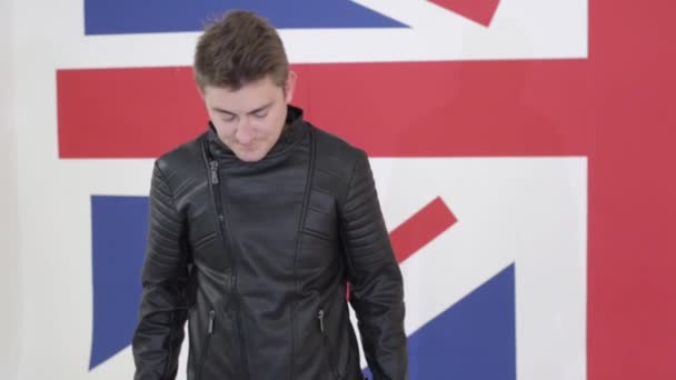 Handsome blue eyed guy in leather motorcycle jacket stands and sings. — Stock Video