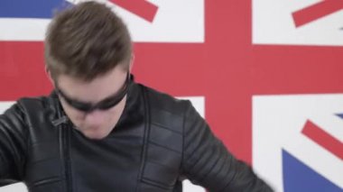 Saç kesimi ve güneş gözlüğü deri motosiklet ceket danslar içinde beyaz adam.