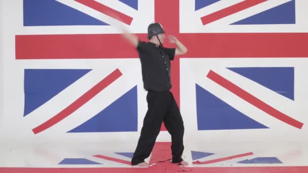 Homme artistique avec casque gardien imite pointeur en studio avec drapeau britannique — Video