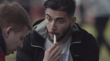 Saint Petersburg, Rusya - 24 Haziran 2017: Genç hipster adam Elektrik Sigara İçilmeyen kalabalık şehir park Festivali