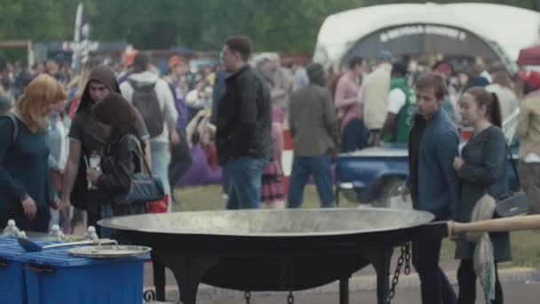 САЙНТ-ПЕТЕРБУРГ, РОССИЯ - 24 июня 2017 года: Люди, идущие вдоль азиатской уличной еды большой паровой котел на переполненном фестивале в парке — стоковое видео