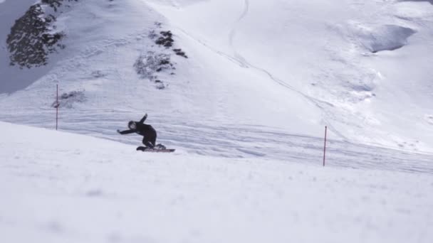 Estación de esquí. Paseo snowboarder en la pendiente, abruptamente se rompe. Rocío de nieve. Día soleado — Vídeos de Stock