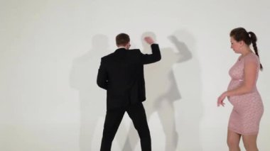 Sevimli erkek gömlek ve hamile kadın ile siyah elbiseli ışık odada dans