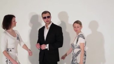 Güzel kadın ve çekici erkek takım elbise ve güneş gözlüğü dans Şirket