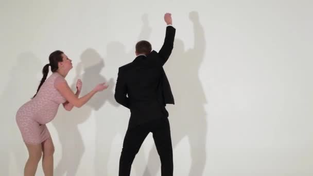 Handsome man in suit with shirt and pregnant female are dancing in light room — Stock Video