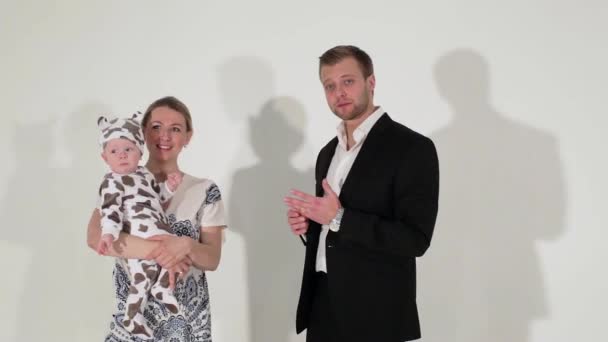 Mature blue-eyed man in suit stands next to woman who is holding baby in hands. — Stock Video