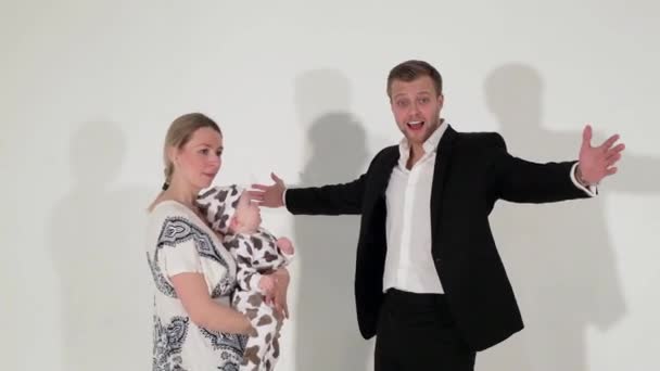 Mature blue-eyed male in suit stands next to woman who is holding baby in hands. — Stock Video