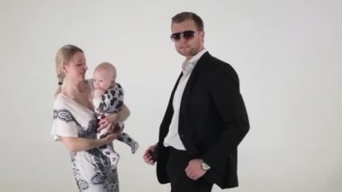 Güzel mavi gözlü kadın holding bebek elinde ile takım elbise dansları şirin.