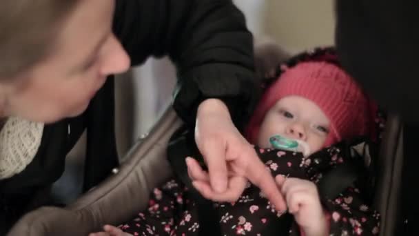 Vrouw, moeder speelt met haar baby liying in baby draagtas met tepel — Stockvideo