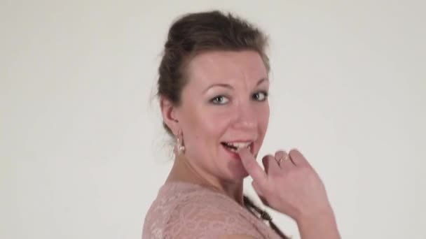 Brunette femme aux cheveux longs avec des boucles d'oreilles en robe rose danse sur la caméra — Video